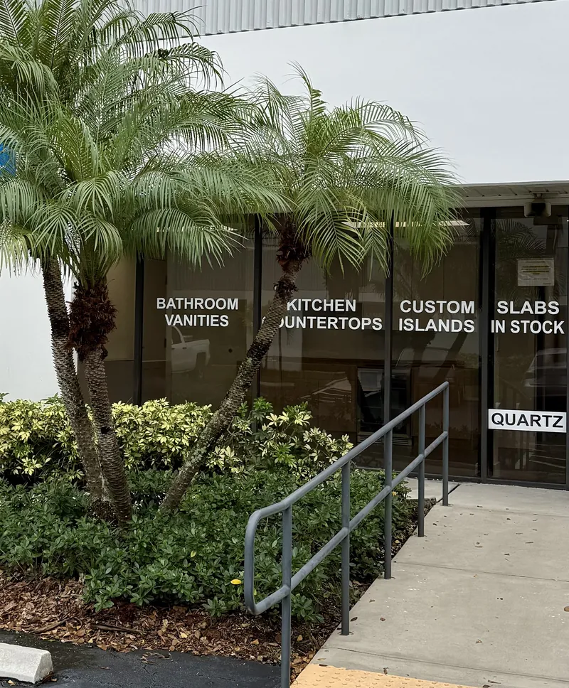 American Countertops & Design showroom windows on Corporate Drive, lettered for bathroom vanities, kitchen countertops, custom islands and slabs in stock