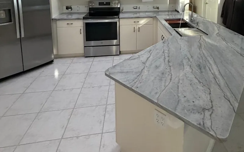 Kitchen with an angled counter, an undermount sink and stainless steel appliances