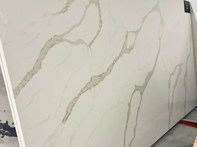 White slab with bold gold-toned veins standing on a rack