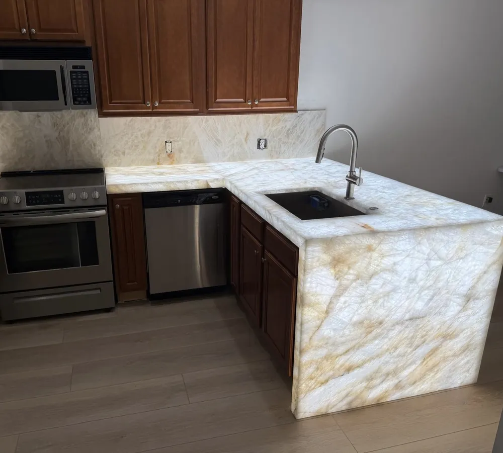 Finished kitchen with a stone peninsula, a waterfall end panel and an undermount sink