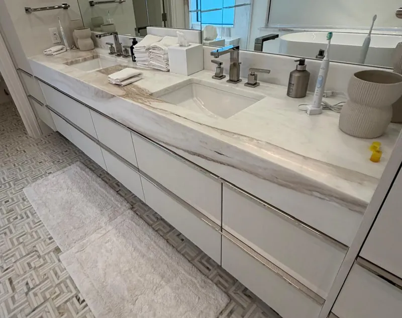 Floating double vanity with a thick white veined top and two undermount sinks