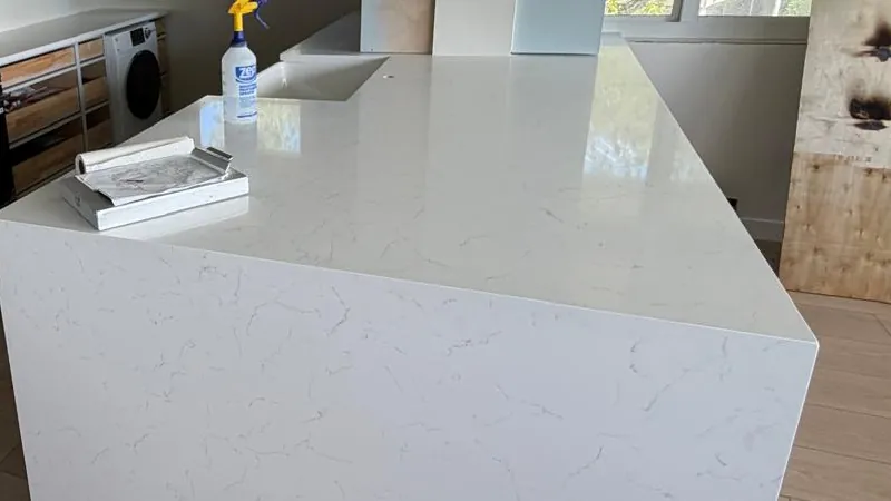 White veined waterfall island with a mitered corner, on a wood floor