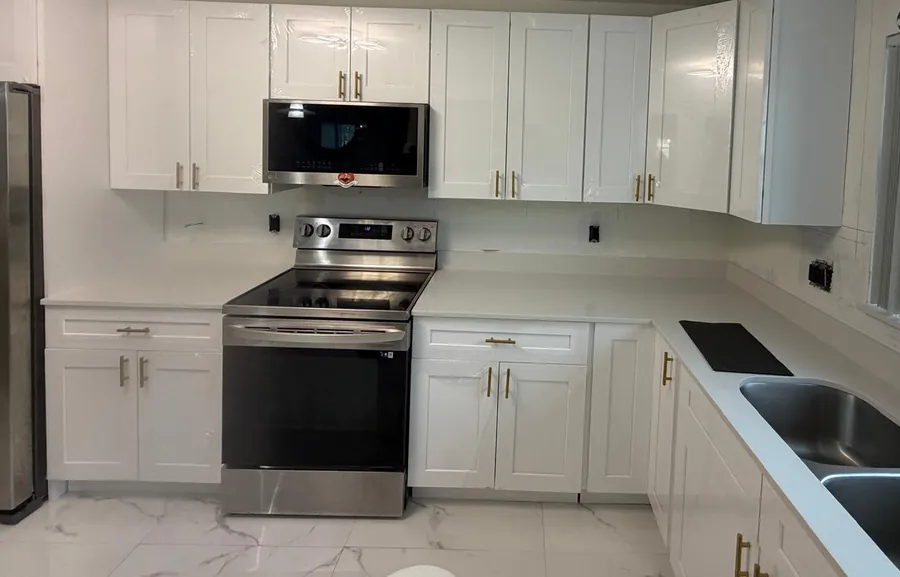 White shaker kitchen with white countertops, a stainless range and a double undermount sink