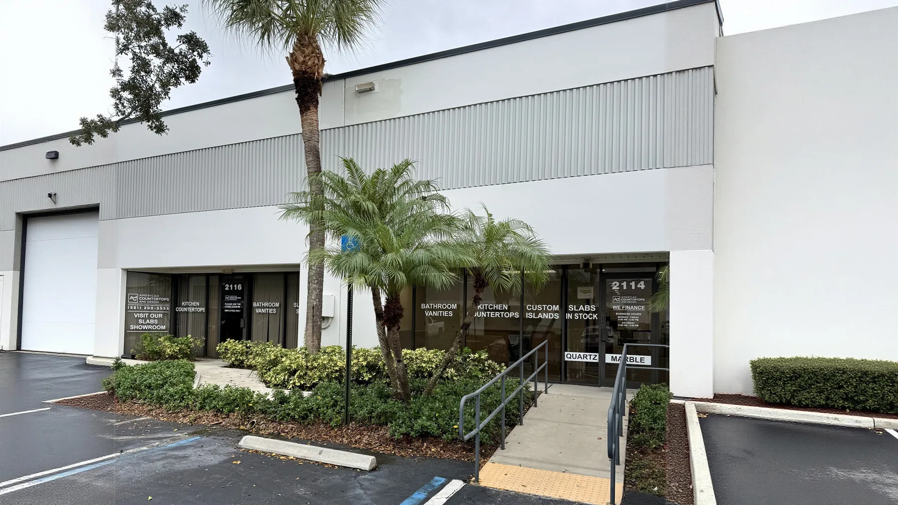 Both American Countertops & Design storefronts side by side in Boynton Beach — unit 2116 on the left and unit 2114 with the ramped main entrance on the right