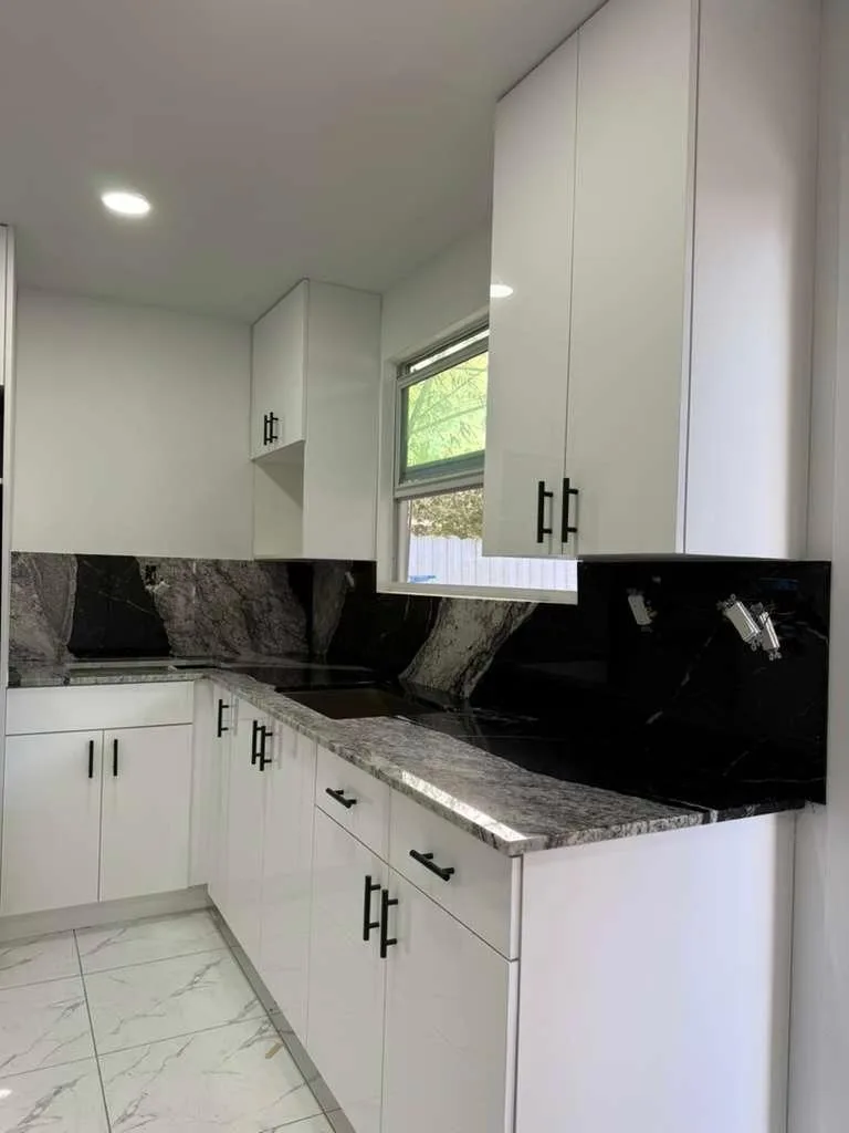 Black granite countertops with full-height granite backsplash