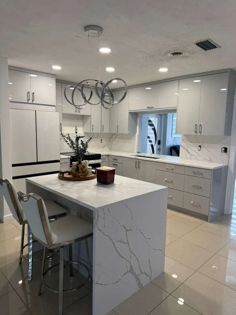 White quartz waterfall island with bar stools
