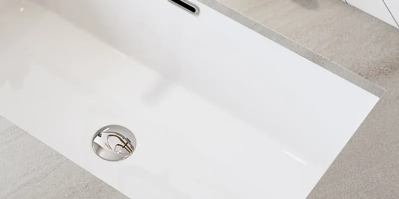 White rectangular undermount sink set below a light gray vanity counter, manufacturer photo